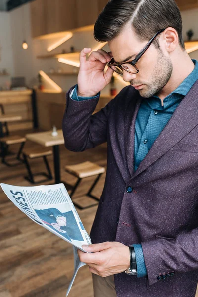 Uomo d'affari che legge giornale in caffè — Foto stock