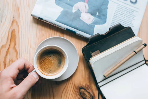 Uomo d'affari con tazza di caffè e quaderno sul tavolo — Foto stock