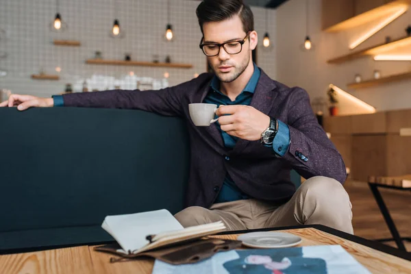 Businessman drinking coffee in coffee shop — Stock Photo