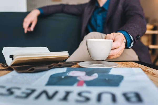 Hombre de negocios descansando en el sofá en la cafetería - foto de stock