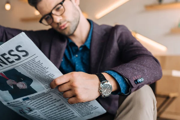 Businessman reading newspaper in coffee shop — Stock Photo