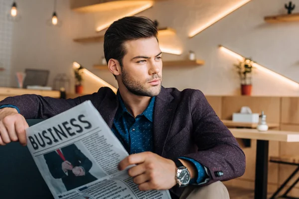 Uomo d'affari con giornale d'affari in caffè — Foto stock