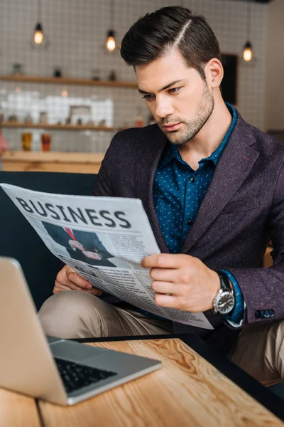Businessman reading newspaper in coffee shop — Stock Photo