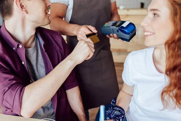 Casal pagando com cartão de crédito no café — Fotografia de Stock