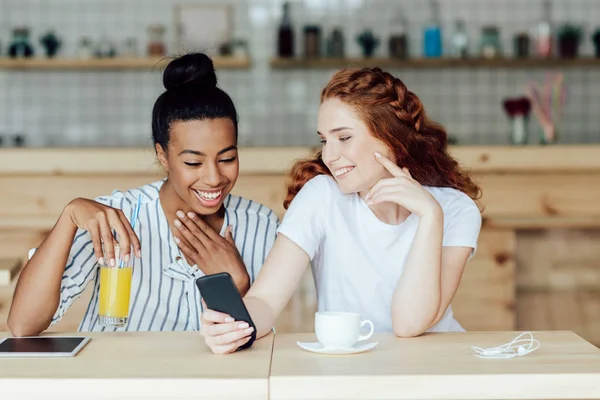 Multiethnic girls using smartphone — Stock Photo