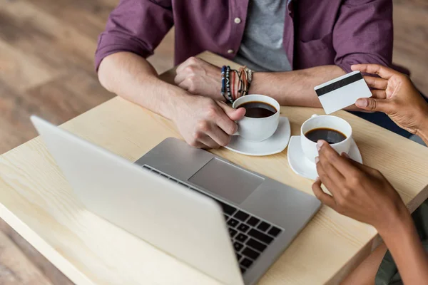 Pareja con café, tarjeta de crédito y portátil - foto de stock