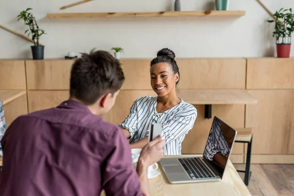 Multiethnic couple with laptop and credit card — Stock Photo