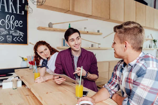 Amigos usando tableta digital en la cafetería — Stock Photo