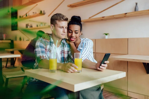 Pareja multiétnica usando smartphone - foto de stock