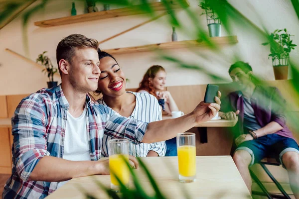 Multiethnic couple taking selfie — Stock Photo