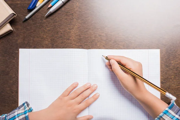 Kid writing in notebook — Stock Photo