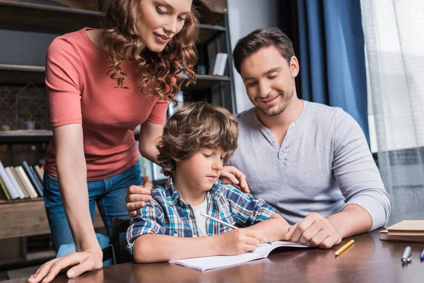 Parents helping son with homework — Stock Photo