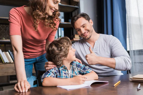 Родители помогают сыну с домашним заданием — стоковое фото