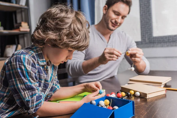 Padre e hijo jugando con el modelo de átomos - foto de stock