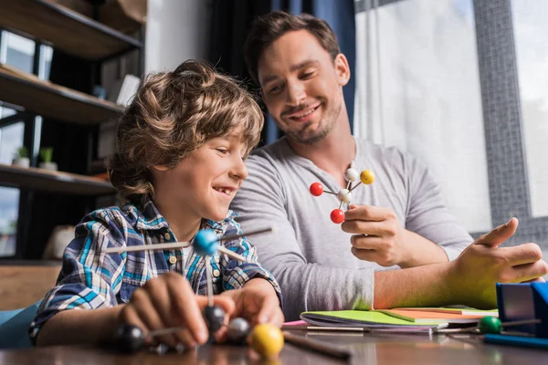 Père et fils jouant avec le modèle d'atomes — Photo de stock