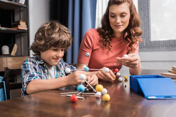 Familia jugando con el modelo de átomos - foto de stock