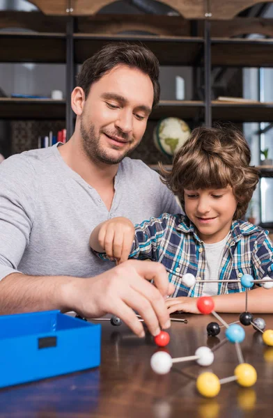 Père et fils jouant avec le modèle d'atomes — Photo de stock