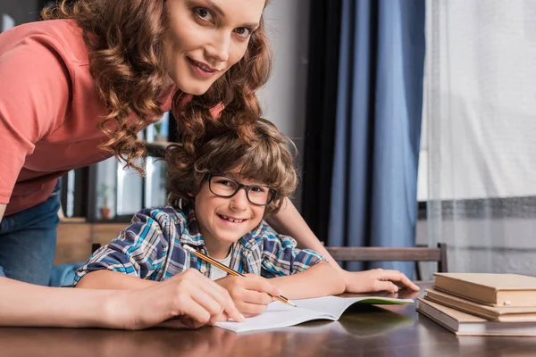 Mutter hilft Sohn bei Hausaufgaben — Stockfoto