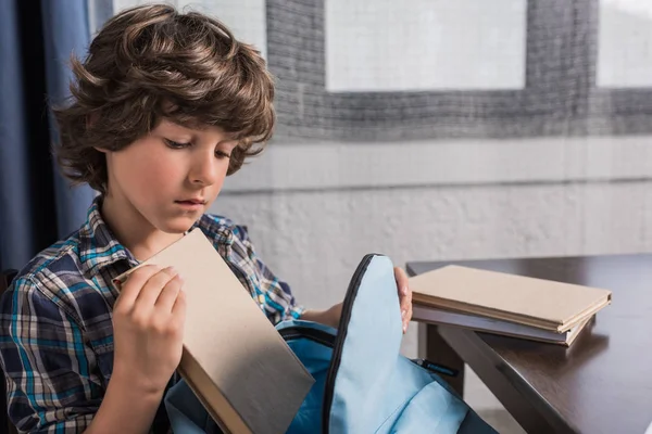 Child packing backpack for school — Stock Photo