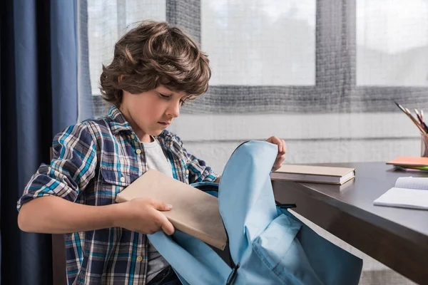 Child packing backpack for school — Stock Photo