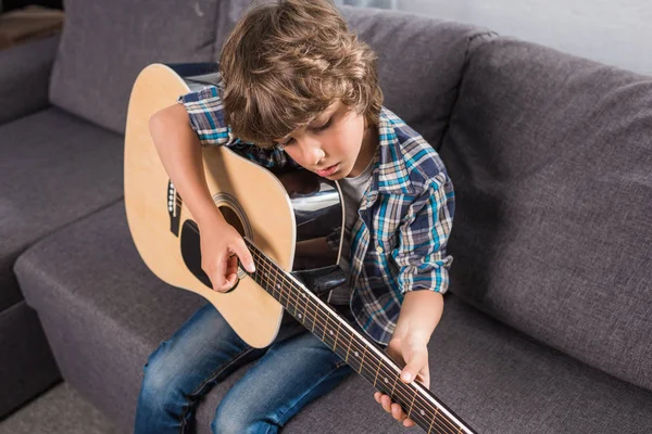 Niño tocando la guitarra acústica - foto de stock