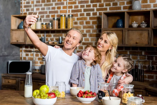 Familia tomando selfie durante el desayuno - foto de stock