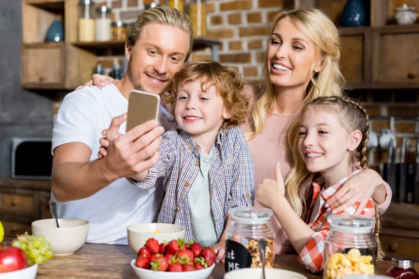 Familia tomando selfie durante el desayuno - foto de stock