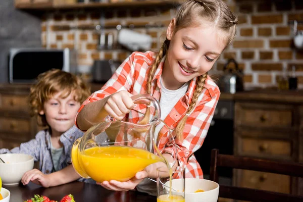 Hermanos con jugo en el desayuno - foto de stock