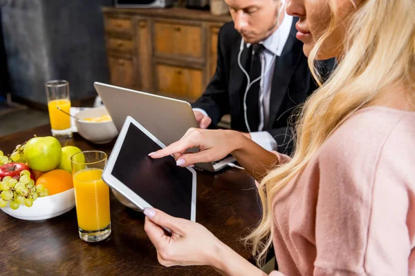 Paar benutzt Gadgets beim Frühstück — Stockfoto