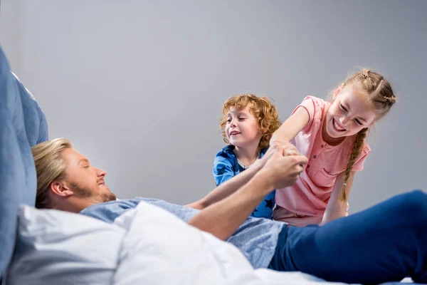 Pai com filhos na cama — Fotografia de Stock