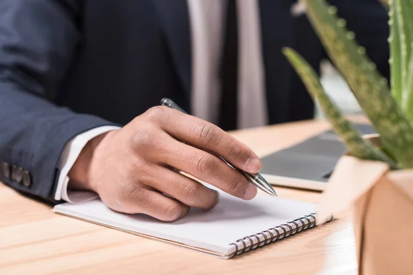 Uomo d'affari che scrive nel quaderno — Foto stock