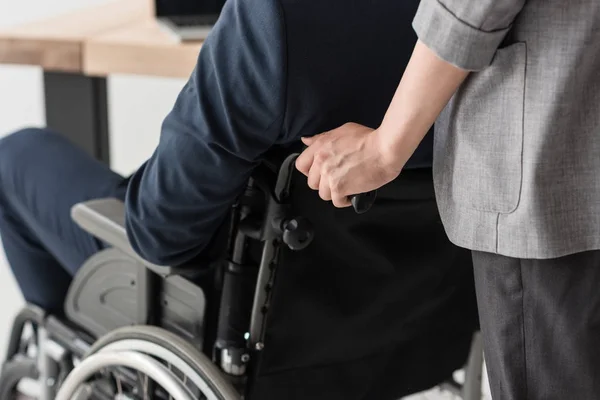 Mujer de negocios ayudando a colega discapacitado - foto de stock