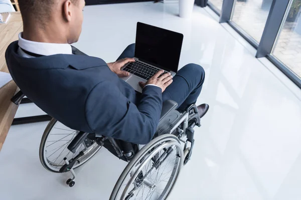 Hombre de negocios afroamericano discapacitado con portátil - foto de stock