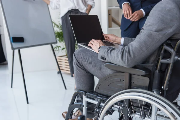 Hombre de negocios discapacitado trabajando en portátil - foto de stock