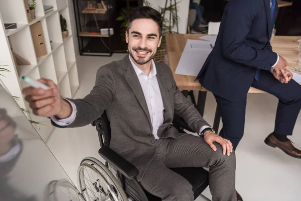 Empresário com deficiência apontando para quadro branco — Fotografia de Stock