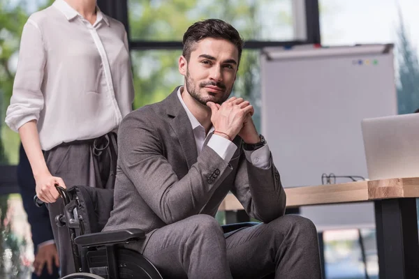 Hombre de negocios discapacitado en silla de ruedas en oficina - foto de stock