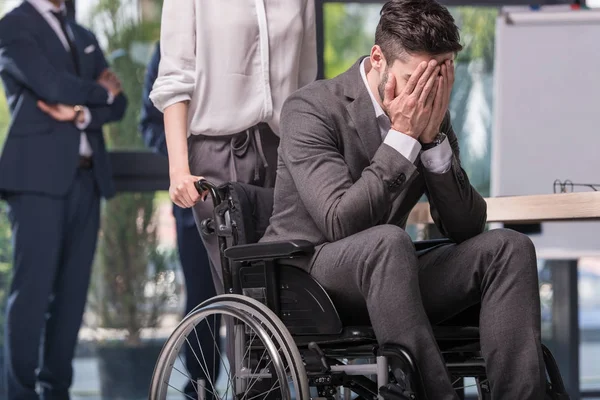 Hombre de negocios discapacitado en silla de ruedas en oficina - foto de stock