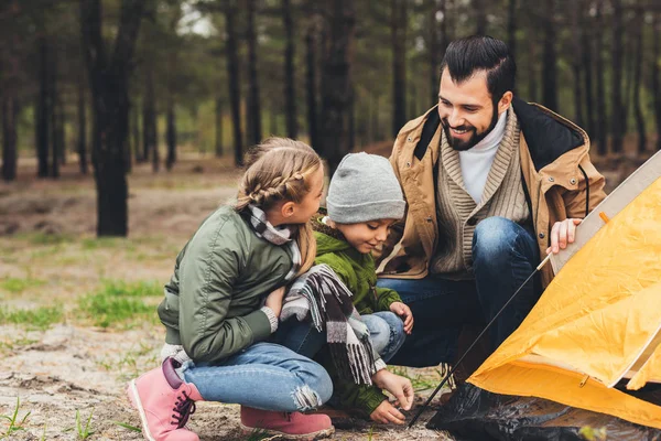 Pai e crianças instalando barraca de acampamento — Fotografia de Stock