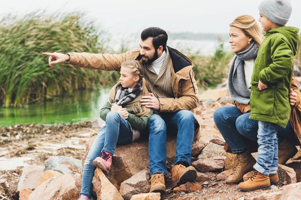 Famiglia seduta sulla costa rocciosa — Foto stock