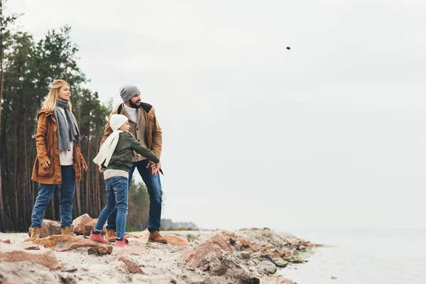 Famille jetant des pierres en mer — Photo de stock