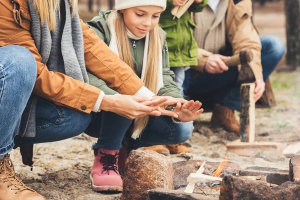 Family warming hands with campfire — Stock Photo