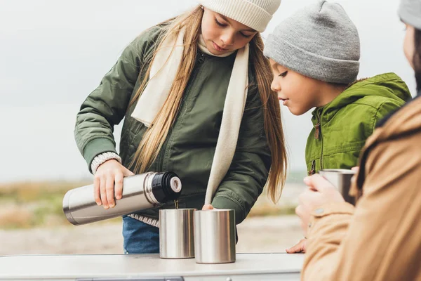 Mädchen gießt Tee für Bruder und Vater — Stockfoto