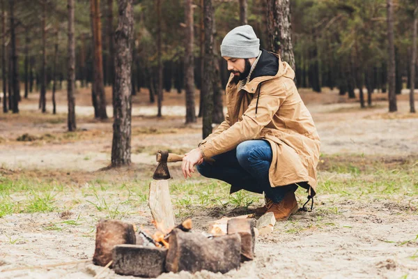 Man cutting wood for bonfire — Stock Photo