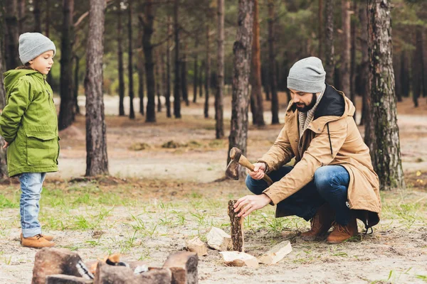 Father and son cutting wood for bonfire — Stock Photo