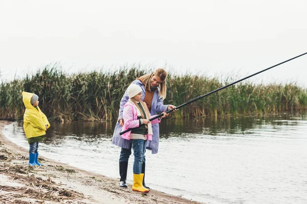 Mother and kids fishing together — Stock Photo
