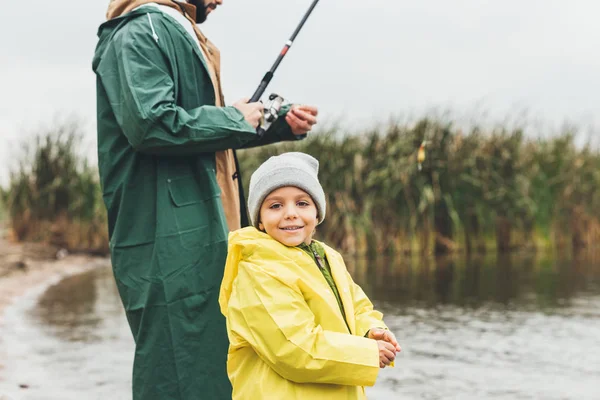 Hijo pesca con padre - foto de stock