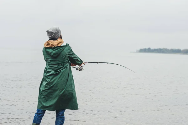 Hombre pescando en día lluvioso - foto de stock