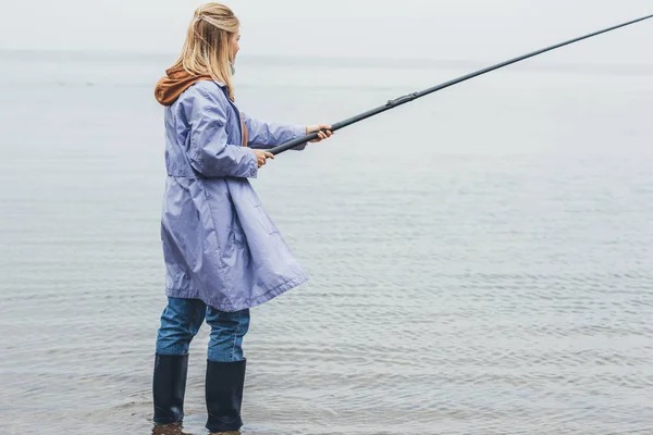 Frau angelt an bewölktem Tag — Stockfoto