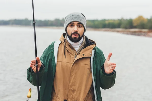 Hombre mostrando el tamaño de los peces - foto de stock