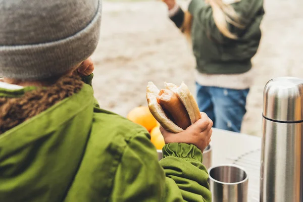 Boy holding hot dog outdoors — Stock Photo